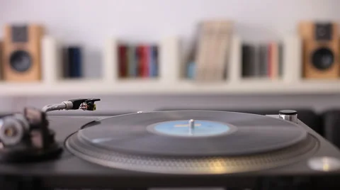 A man with jacket starting a retro record player Stock-Footage 58337494