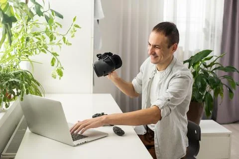 A man in a jacket is studying a new profession. A VR programmer plays a virtual Stock-Fotos