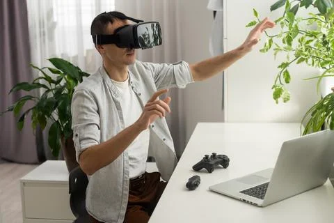 A man in a jacket is studying a new profession. A VR programmer plays a virtual Stock-Fotos