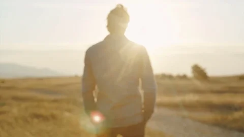 Man in a jacket in the sun looks at the sunset Stock Footage 79410955