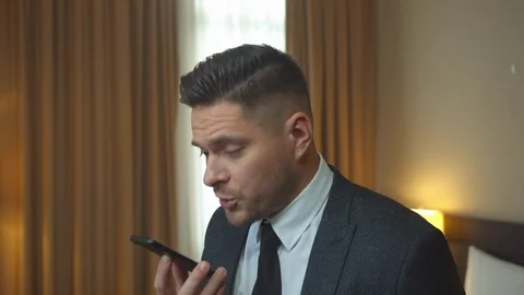 Man in jacket talk on phone nervously in room of the hotel Stock Footage 121941295