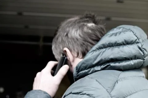 A man in a jacket talking on a mobile phone. Stock Photos