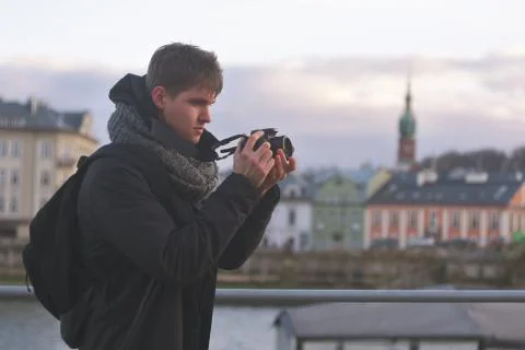 A man in a jacket with a tourist backpack on the background of a tourist, typ Stock Photos
