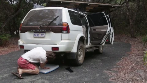 Man jacking up a vehicle with jack Stock Footage 70767883