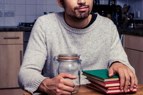 Man with jam jar and stack of books Stock-Fotos