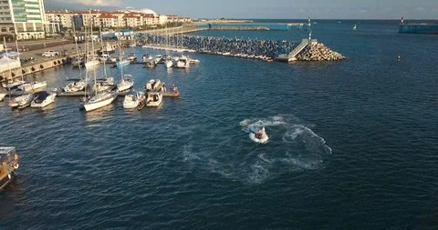 Man on a jet-ski does stunts flip in the bay. Shooting from the air front Stock Footage 85594278