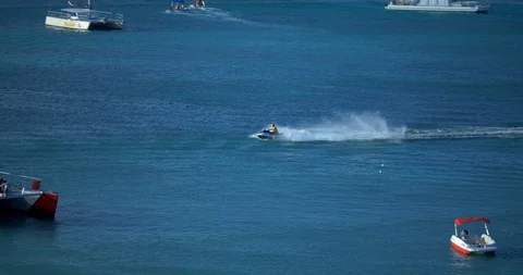 Man on Jet Ski in Ocean, Wave Runner on Tropical Water Near Boats 動画素材 103220733
