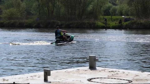 A man on a jet ski passes quickly ride on river, waves on the water. Stock-Footage 130652642