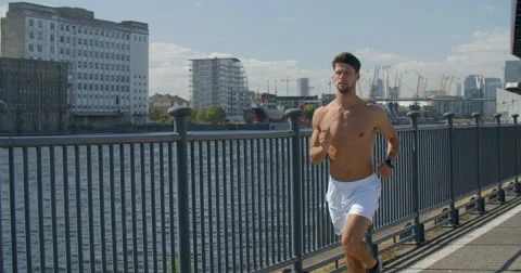 Man Jogging along Docklans with Cityscape in background. Stock-Footage 68043343