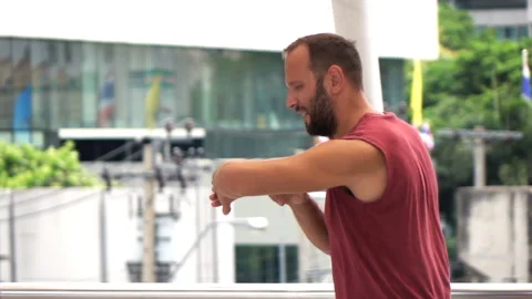 Man jogging and checking time on smartwatch in city, super slow motion 240fps Stock Footage 134640269