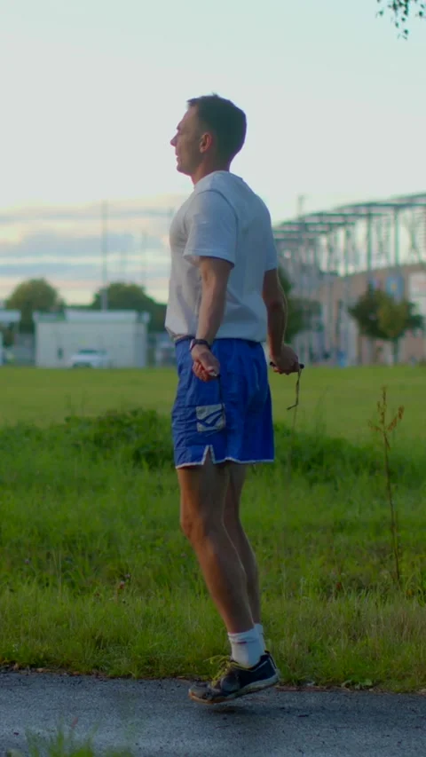 A man is jogging and stretching outside, wearing his sportswear attire Stock Footage 317340550