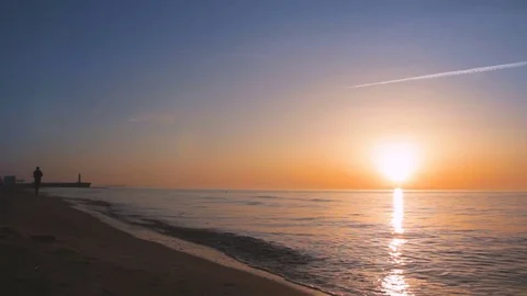 Man jogging on the beach during sunset at the sea shore Vídeos de archivo 75522080