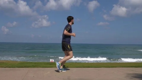 Man jogging on the beach Stock Footage 75933886