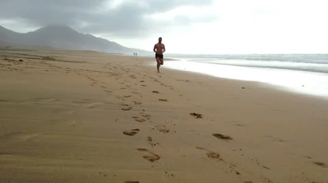 Man jogging on the beach - front view Stock Footage 37733473