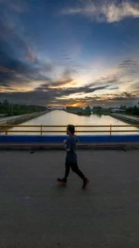 Man Jogging on Bridge at Sunset Stock-Fotos
