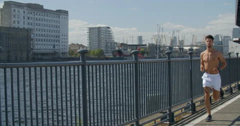 Man jogging with Cityscape and water behind. Vídeo Stock 68043258