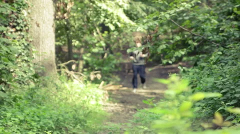 Man jogging downhill through forest Stock Footage 41097747