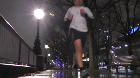 Man jogging on footpath at night in the rain Stock Footage 44685632