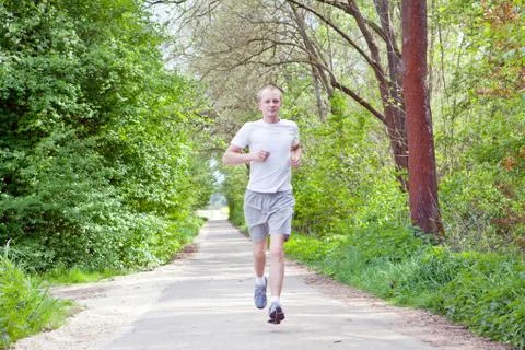 Man is jogging in the forest Stock Photos