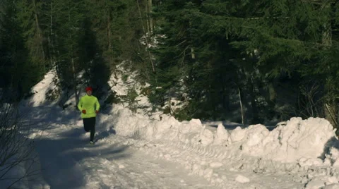 Man jogging in the forest at winter, steadycam shot, slow motion shot at 240fps Stock-Footage 47084527