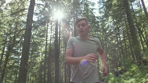 A man jogging in a green forest Stock Footage 236928926