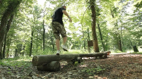 Man Jogging - jumping over tree trunk obstacles Stock Footage 35894379