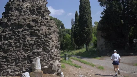Man Jogging Next To Ruins On The Appian Way In Rome, Italy Stock Footage 154880712