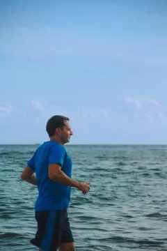 Man Jogging by the Ocean Stock Photos