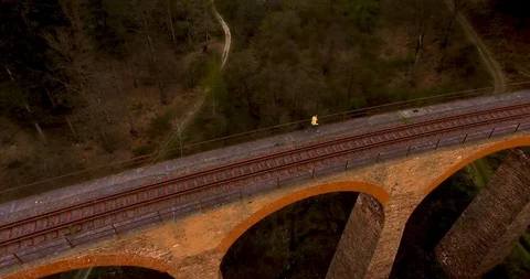 A man jogging over the side of a railway bridge Stock Footage 89651682