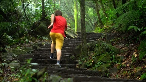 Man Jogging Up Stairs in Forest in Silly Way Stock Footage 106657266