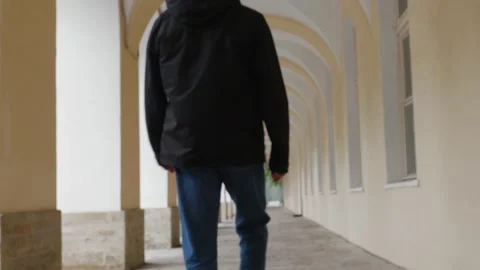 Man jogging through arched colonnade corridor perspective Stock Footage 345700307