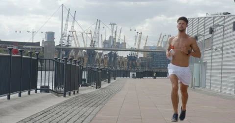 Man Jogging through City Docklands. Vídeo Stock 68124549