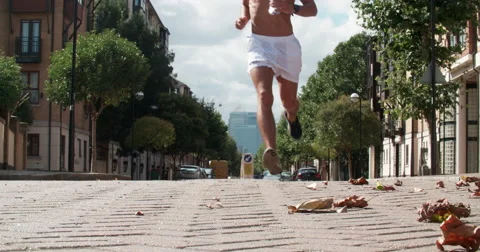 Man Jogging through City Streets Takes sip of water. Vídeo Stock 68124104