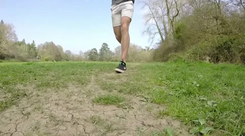 Man jogging through field towards camera Stock Footage 49213104