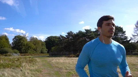 Man Jogging through Park in Summer, Slow Motion Stock Footage 96047195