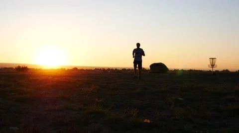Man jogging towards the sunset. Stock Footage 54513733