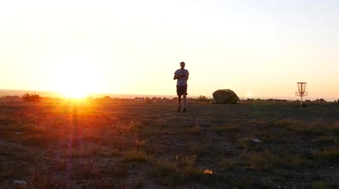 Man jogging towards the sunset. Stock Footage 54513921