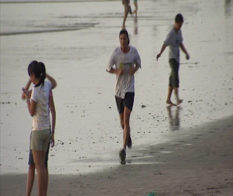 Man jogging on wet sand at beach Stock Footage 86747196