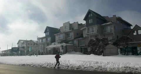 Man Jogs Along Road in Front of Empty Ski Resort During Covid 19 Shutdown Stock Footage 137851762