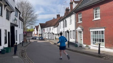 Man jogs down the historic Fishpool street on a suny Spring day Vidéo 151460244