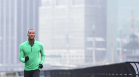 A man jogs towards the camera in front of skyscrapers in New York in the rain Stock Footage 45078449