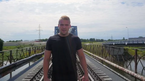 A man jogs towards the camera in front of the old bridge Video stock 84004380