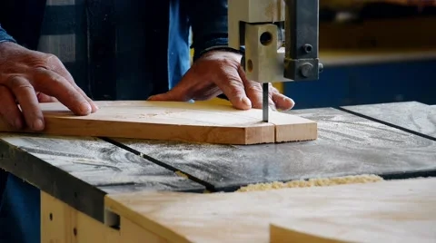 The man on the joiner's machine saws a wooden board Stock Footage 56232536