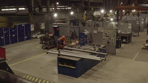 Man joins elements in spacious workshop divided into zones 動画素材 329004148