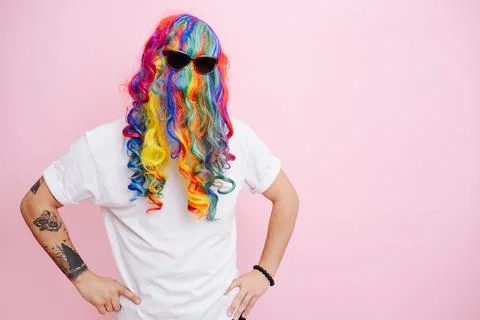 A man jokingly put on a multi-colored wig and glasses on his head Stock Photos