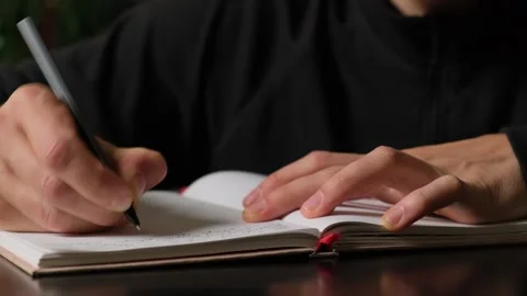 Man journaling his thoughts in a notebook at home, reflecting on personal Stock Footage 316069708