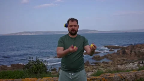 A man juggles on the beach Stock Footage 189917438