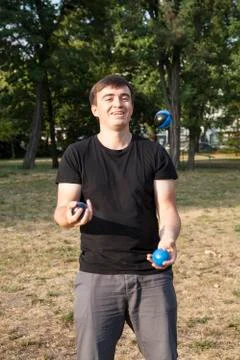 Man juggles in a park Stock Photos