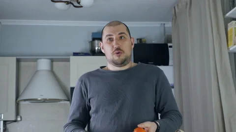 Man juggling fruit in the kitchen after shopping. Concept of fun and healthy Stock Footage 155357019