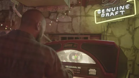 Man at jukebox in bar Stock Footage 323479803